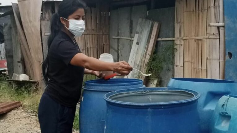 Una trabajadora del Ministerio de Salud destruye criaderos de mosquitos en la parroquia Tenguel, el 13 de mayo de 2024.