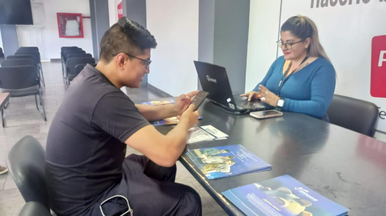 Imagen referencial de una funcionaria del Biess ofreciendo información sobre créditos del Biess a un trabajador de una empresa privada, mayo de 2024.