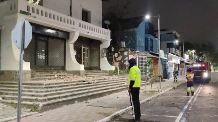 Personal de tránsito y bomberos en la calle Juan León Mera, en Quito, junto a una vivienda con colapso estructural, el 1 de julio de 2024.