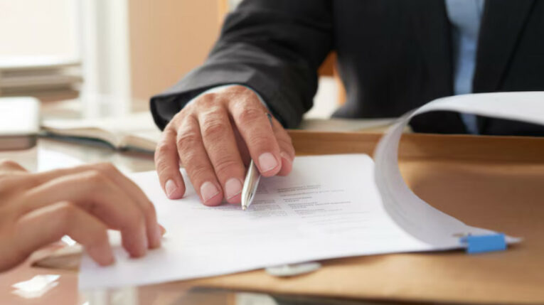 Imagen referencial de dos personas revisando un documento.