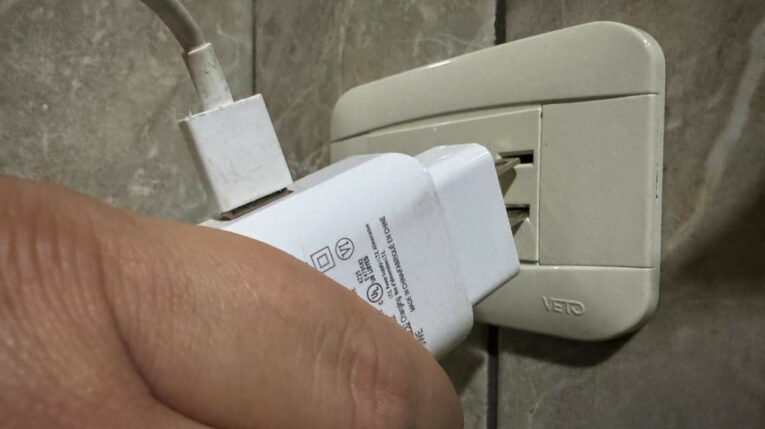 Imagen referencial de una persona conectando un cargador en un interruptor en Ecuador, en julio de 2024.