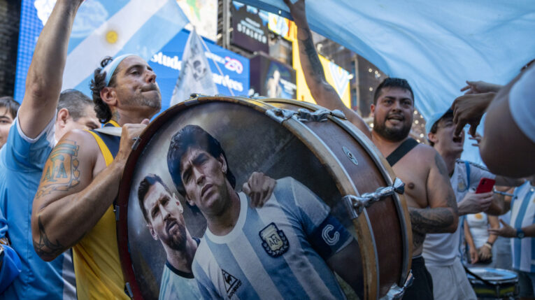 Aficionados de la selección argentina de fútbol animan al equipo durante un 'banderazo' en la plaza de Times Square, este lunes en Nueva York (Estados Unidos).