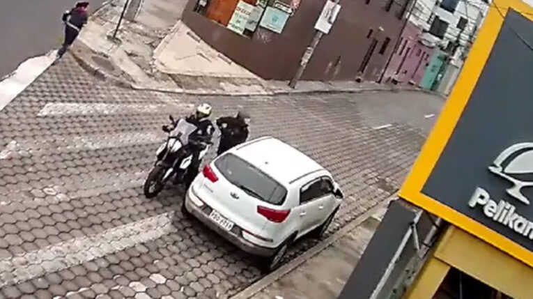 Dos delincuentes roban a los ocupantes de un vehículo en Quito, el 23 de octubre de 2023.
