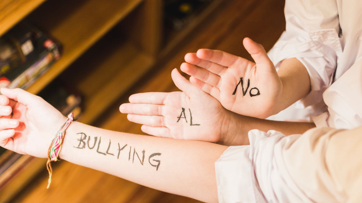 No al bullying escrito en brazos de niños