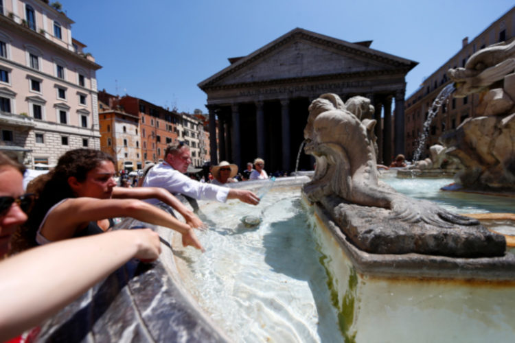 Turistas se refrescan en una fuente del centro de Roma. 