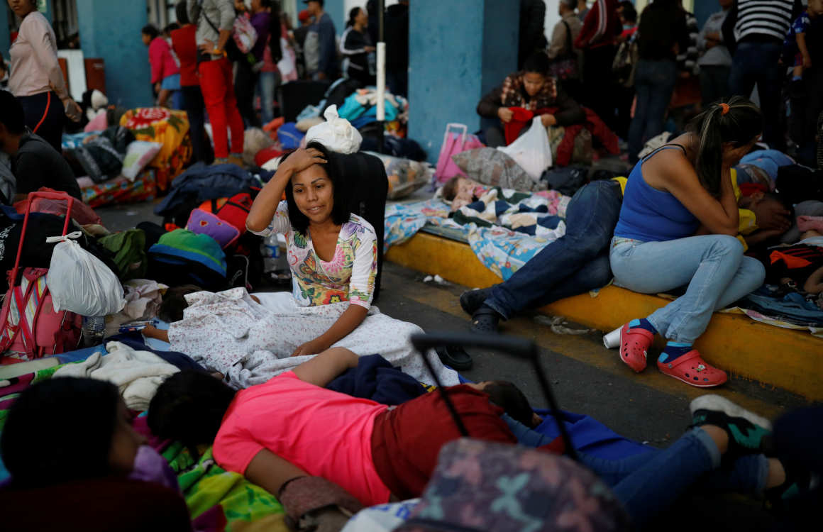Ciudadanos venezolanos descansan en el paso fronterizo entre Ecuador y Perú.