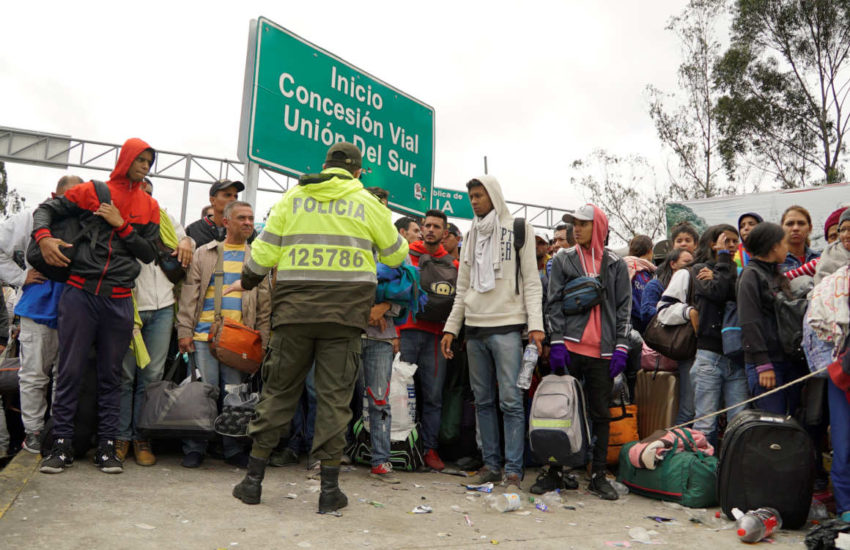 Un grupo de ciudadanos venezolanos espera en el punte internacional de Rumichaca para ingresar a Ecuador y luego avanzar hasta Perú.