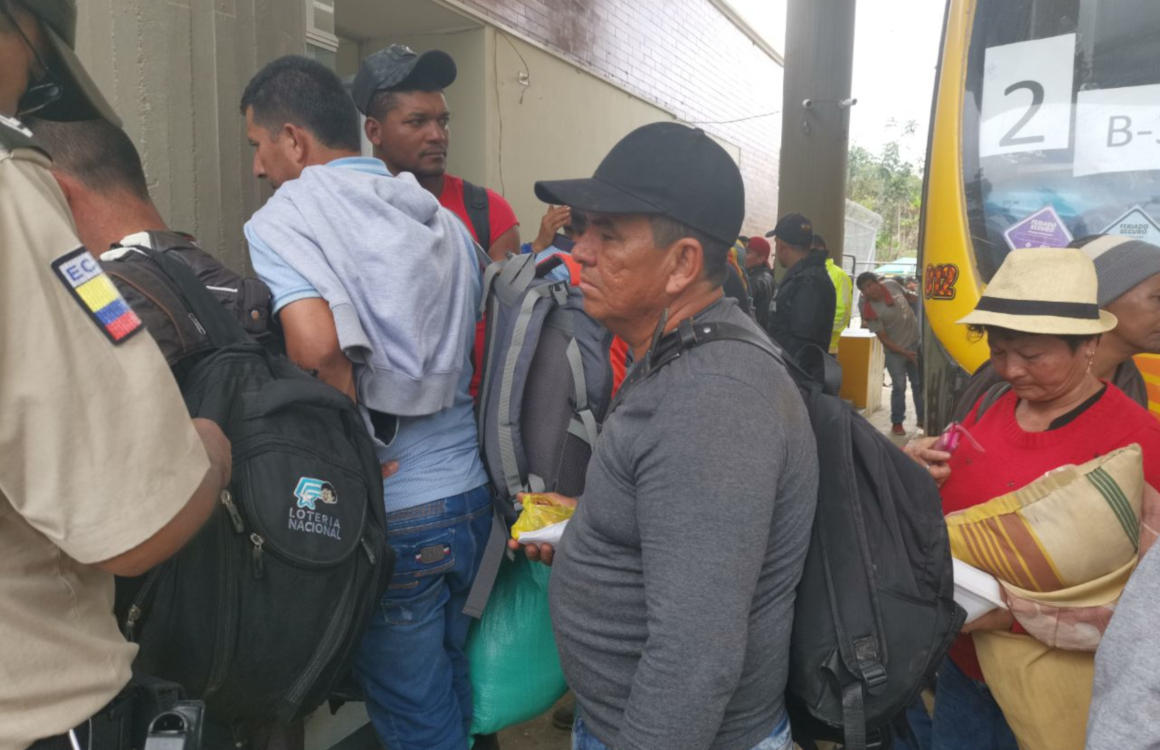 Un grupo de mineros ilegales de Buenos Aires espera la revisión de sus documentos para movilizarse en un bus.