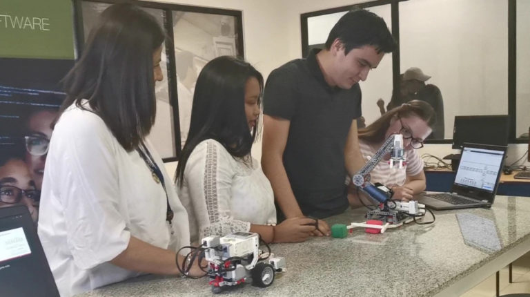 Estudiantes de la UDLA junto a un robot Lego