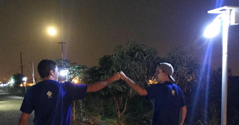 Voluntarios de 'Un litro de luz', después de instalar un poste de luz con energía solar en Guayaquil.