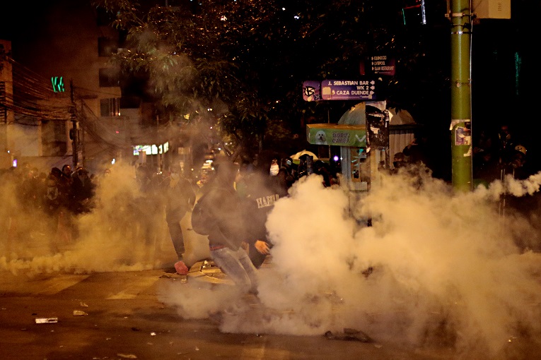 La Policía contiene el avance de los manifestantes con gases lacrimógenos durante la noche del 23 de octubre. 