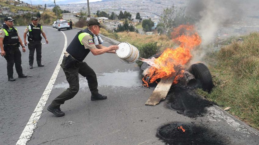 Policías apagan neumáticos ardiendo el viernes 4 de octubre de 2019 en Quito, en el segundo día de estado de excepción decretado por el Gobierno, tras las protestas por las medidas de ajuste económico anunciadas por el gobierno. 