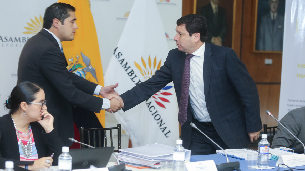 El ministro de Finanzas, Richard Martínez, saluda al presidente de la Comisión de Desarrollo Económico, Esteban Albornoz, durante una comparecencia en la Asamblea.
