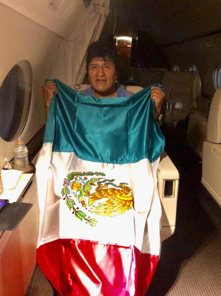 Fotografía cedida por la Cancillería mexicana que muestra al expresidente de Bolivia Evo Morales mientras posa con una bandera mexicana
