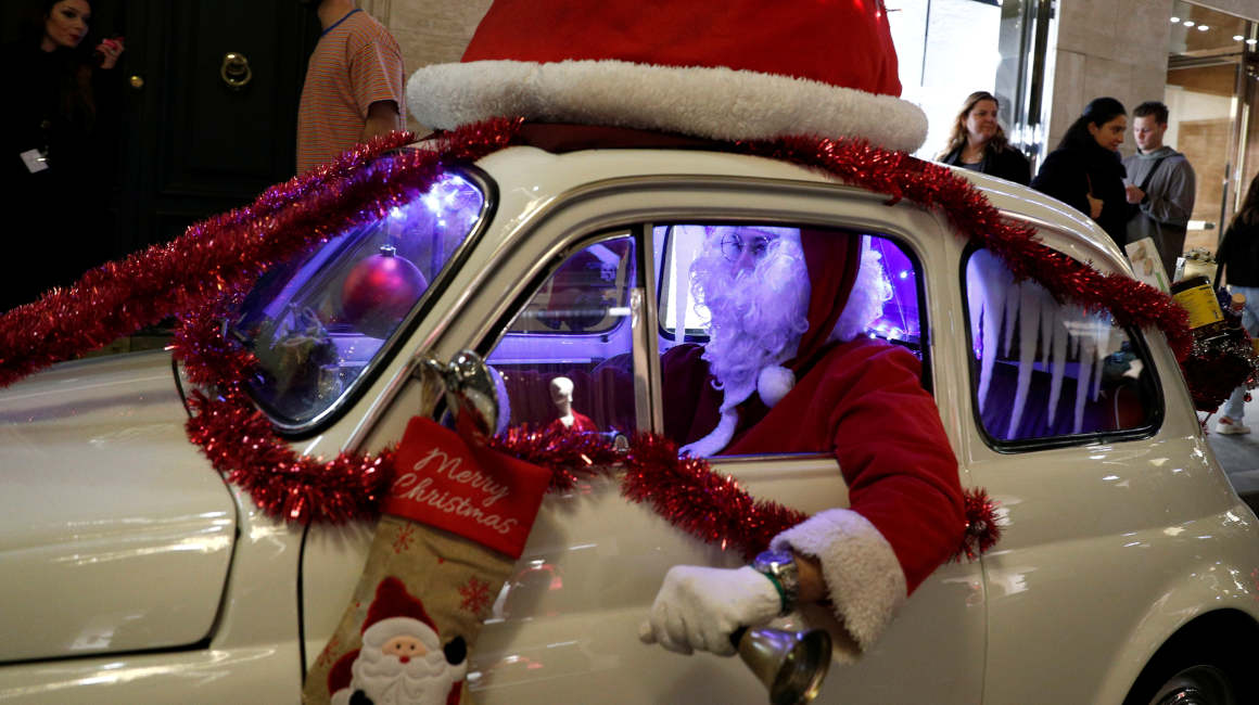 Un hombre vestido como Papá Noel conduce un automóvil Fiat 500, en Roma.