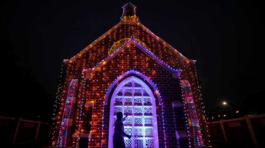 Un hombre instala luces decorativas en una iglesia antes de las celebraciones navideñas en Ahmedabad, India.