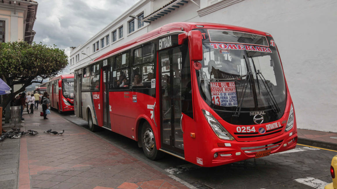 Varios buses de transporte urbano recogen pasajeros en la calle Presidente Córdova, en Cuenca.
