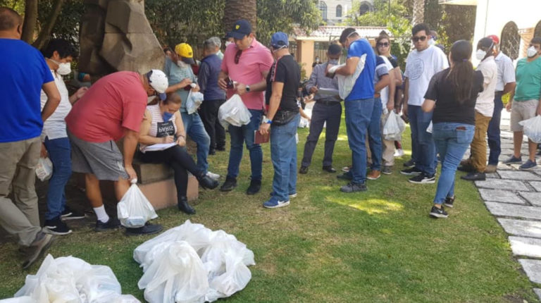 Un grupo de ecuatorianos varados en la Ciudad de México reciben donaciones de comida, el 26 de marzo.