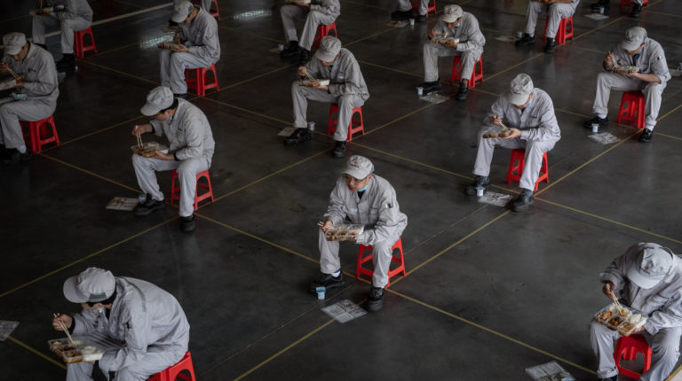 Trabajadores de la empresa Dongfeng Honda en Wuhan, almuerzan a 1,5 metros de distancia. El fabricante de automóviles dice que el 95% de su fuerza laboral ha regresado a sus puestos.