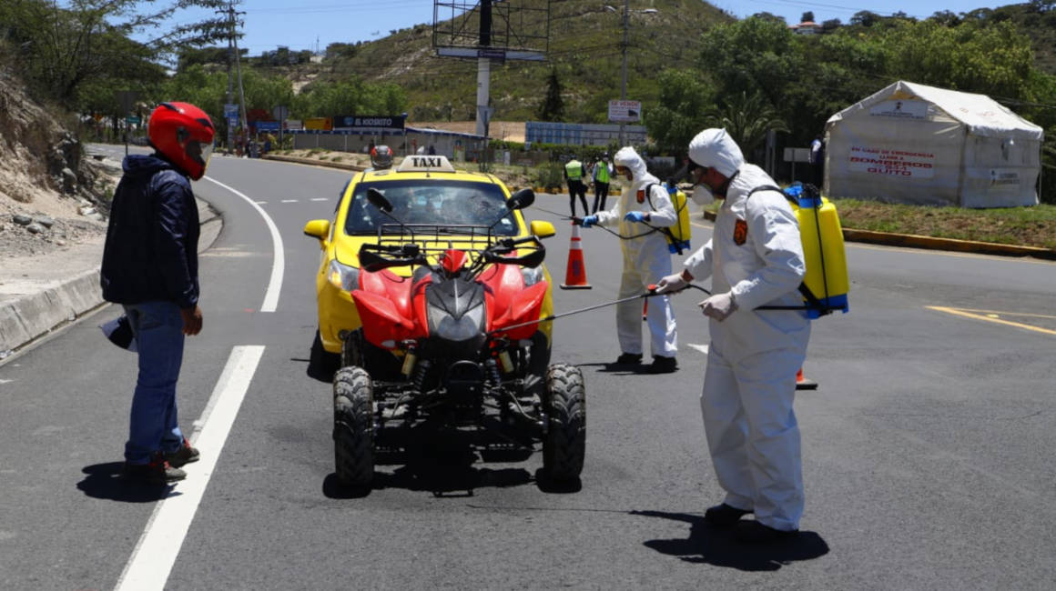 Personal de la Unidad de Riesgos del Municipio de Quito realiza los controles a pasajeros y vehículos en los accesos a la capital de Ecuador el domingo 22 de marzo de 2020.