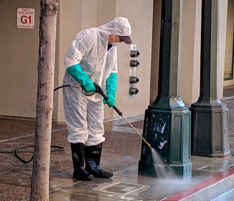 Un empleado municipal mientras limpia las aceras en una calle del barrio del Tenderloin en San Francisco, California. 