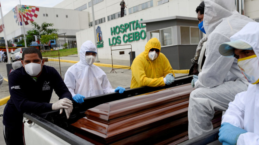 Los trabajadores funerarios esperan con un ataúd en la parte trasera de una camioneta afuera del hospital Los Ceibos, en Guayaquil, el 15 de abril de 2020.