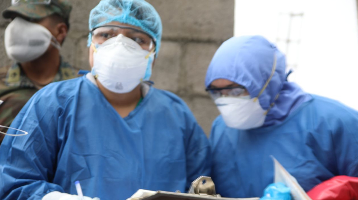 Personal médico durante la toma de muestras de coronavirus en el noroccidente de Quito.