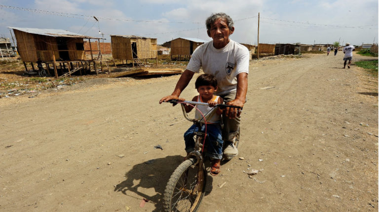 Un adulto mayor y un niño pasean en bicicleta en la zona de Ciudad de Dios en Guayaquil, el 3 de abril de 2020.