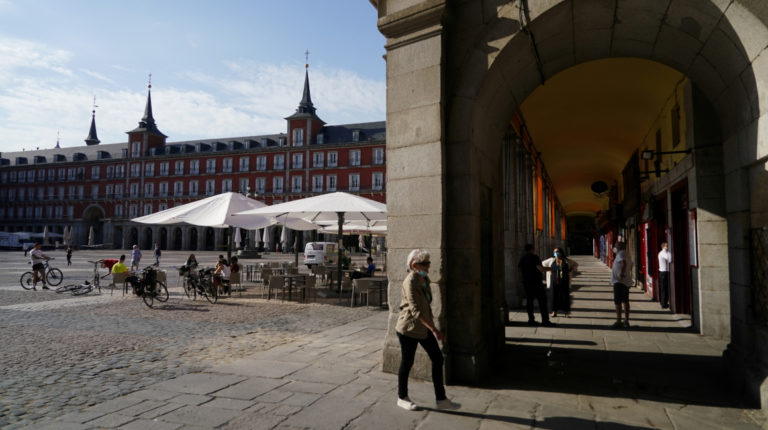 Personas se sientan en una sección al aire libre de un restaurante que reabrió después de dos meses en la Plaza Mayor en Madrid, España, el lunes 25 de mayo de 2020.