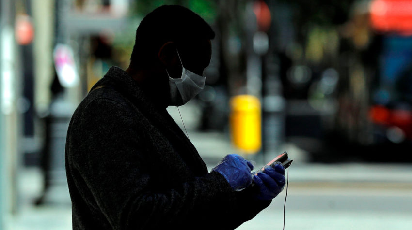 Un hombre con su teléfono móvil en una calle de Singapur.