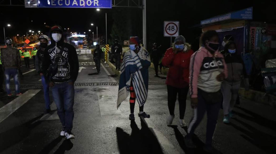 Migrantes venezolanos se repliegan la noche del jueves 30 de abril de 2020, en el puente de Rumichaca, después de que intentaran cruzar por la fuerza y fueran reprimidos con gases lacrimógenos por la Policía colombiana.