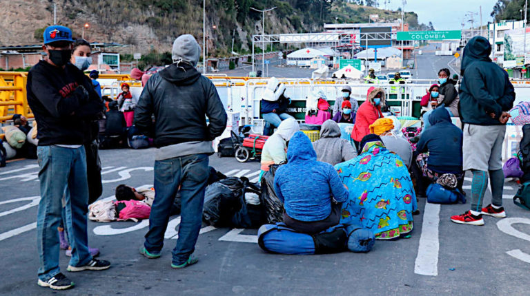 Fotografía cedida por la Prefectura de Carchi ciudadanos venezolanos descansando en el lado ecuatoriano del puente Rumichaca que separa a Ecuador de Colombia, el 29 de abril de 2020.
