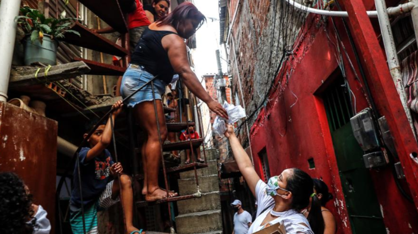 Un voluntaria entrega mascarillas y alcohol en la favela Heliópolis, en Sao Paulo (Brasil) el pasado 26 de junio de 2020.