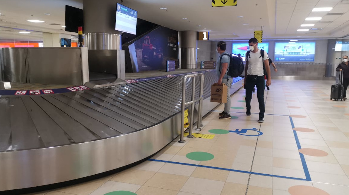 Dos personas recogen sus maletas en el aeropuerto de Quito, el 15 de junio de 2020. 