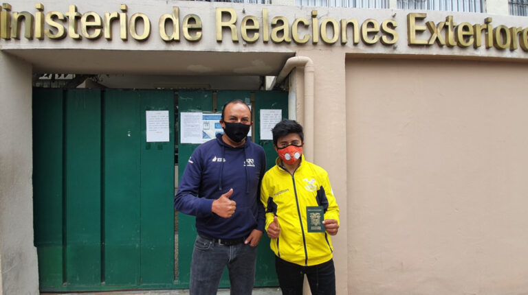 Alexander Cepeda junto a Santiago Rosero, entrenador de la selección ecuatoriana de ciclismo, después de que el ciclista reciba el pasaporte oficial, el 22 de julio de 2020.