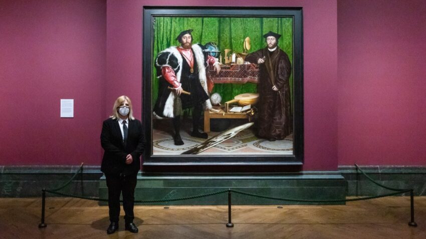 Una mujer del staff de la National Gallery, en Londres, aparece cerca del cuadro "Los embajadores", de Hans Holbein.