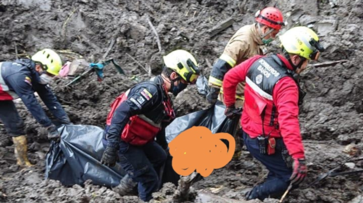 Personal del Cuerpo de Bomberos de Baños de Agua Santa rescata a un de los fallecidos por el deslizamiento de tierra este 6 de julio.