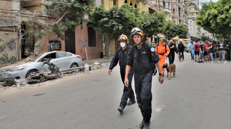 Miembros del Grupo Asesor Internacional de Búsqueda y Rescate (INSARAG) pasan junto a edificios dañados en el área de Mar Meckael en Beirut, Líbano, 09 de agosto de 2020.