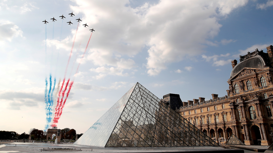 Los aviones de combate franceses pintan el cielo con los colores nacionales sobre la pirámide del Museo del Louvre durante la última etapa del Tour de Francia 2020.