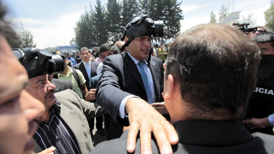 El expresidente Rafael Correa es protegido del gas lacrimógeno, el jueves 30 de septiembre de 2010, durante una protesta de efectivos policiales.