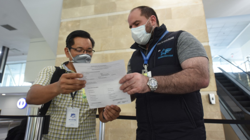 Un pasajero nacional entrega la ficha médica a uno de los funcionarios del Municipio de Guayaquil el pasado 13 de septiembre de 2020.