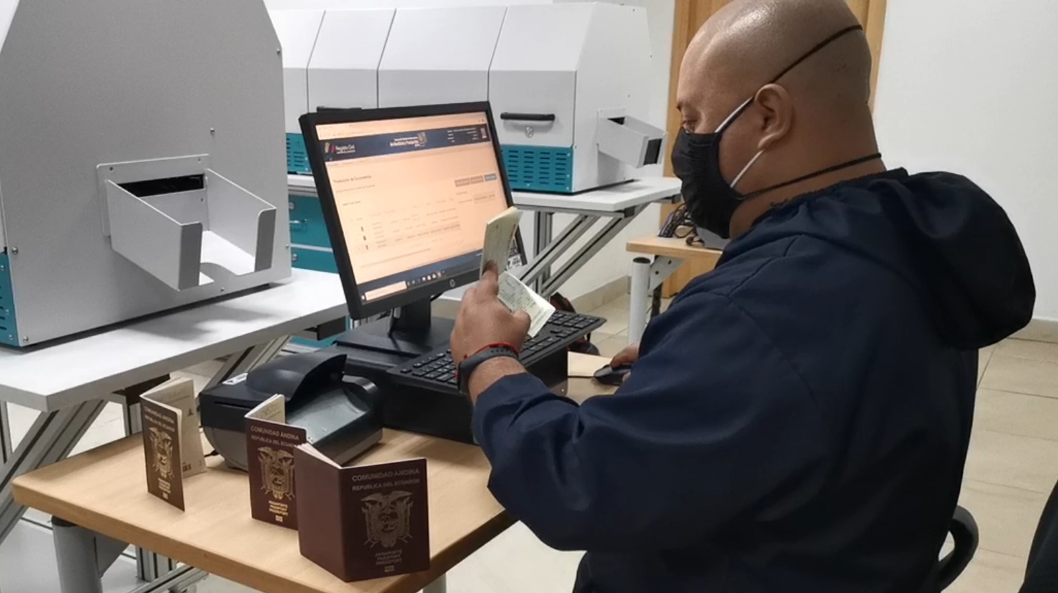 Trabajador del Registro Civil verifica la información de un pasaporte biométrico.