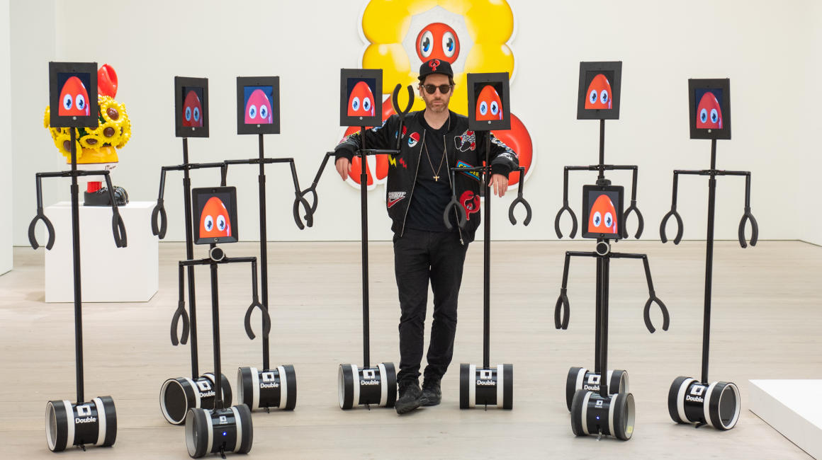 El artista Philip Colbert posa junto a los robots con los que se puede recorrer su exposición en Saatchi Gallery, en Londres, el 28 de octubre de 2020.