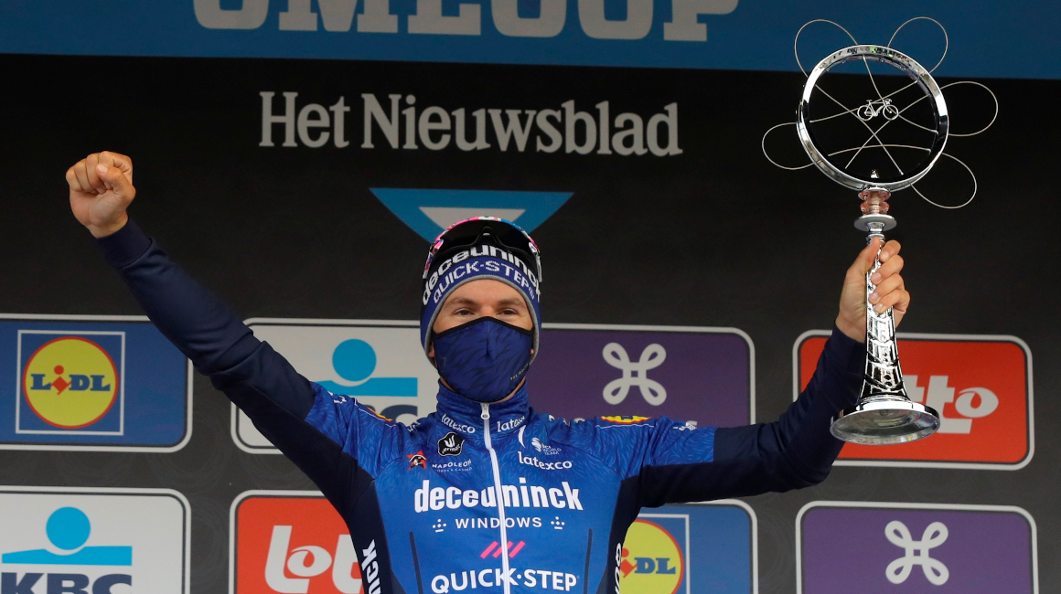 El italiano Davide Ballerini festeja en el podio su título de la clásica Omloop Het Nieuwsblad, el sábado 27 de febrero de 2021.