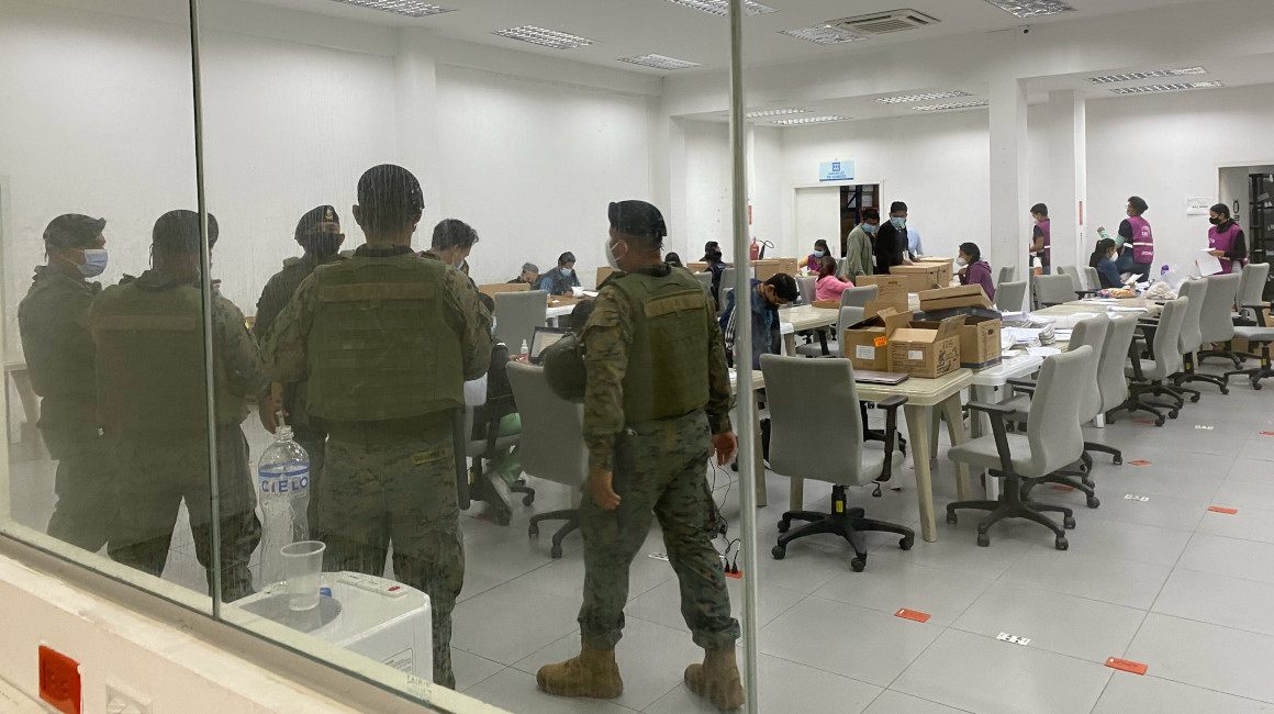 Militares custodian las actas mientras los digitalizadores trabajan en la Junta Electoral del Guayas.