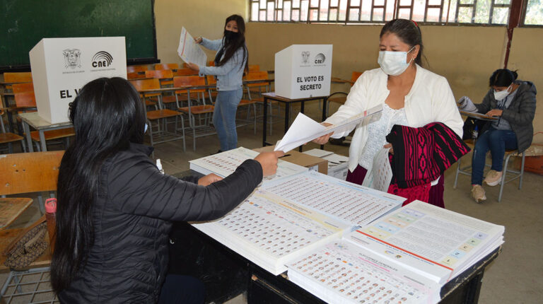 ciudadana recibe las papeletas electorales en un recinto de Cuenca, durante las elecciones