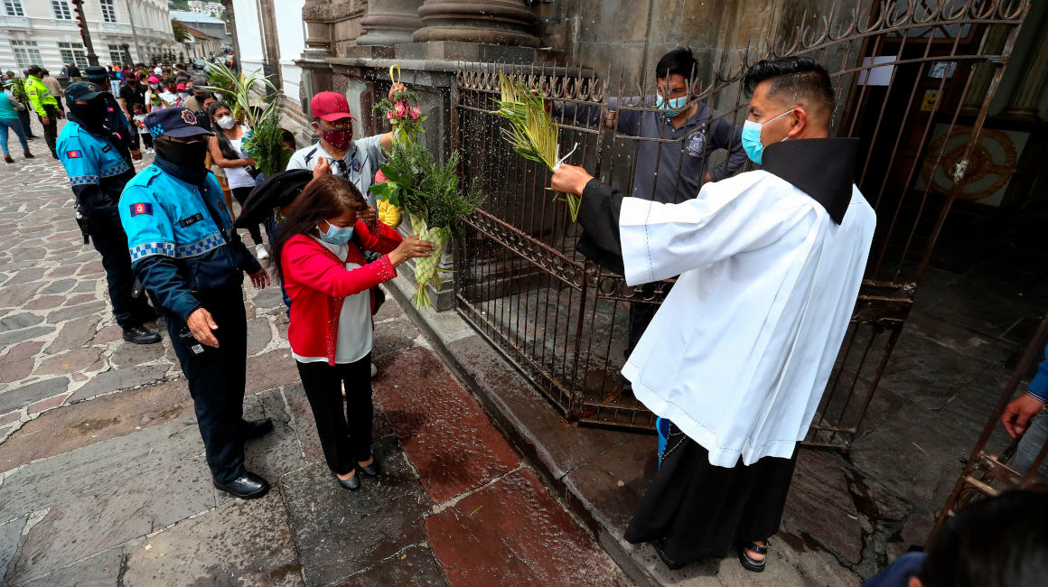 Fieles asisten con ramos por el inicio de la Semana Santa a la iglesia de San Francisco, con un aforo permitido del 30% debido a la pandemia, en el casco histórico de Quito, el 28 de marzo de 2021.