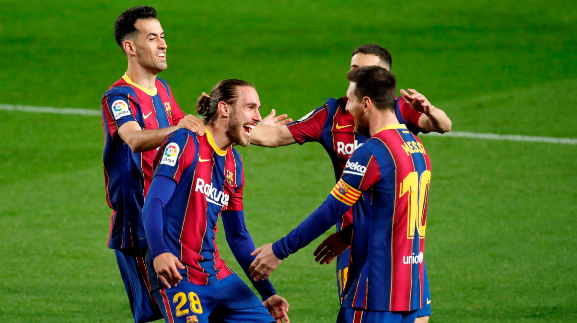 Lionel Messi, Óscar Migueza y Sergio Busquets celebran un gol del FC Barcelona ante la SD Huesca, en un partido de la liga española, el 15 de marzo de 2021.
