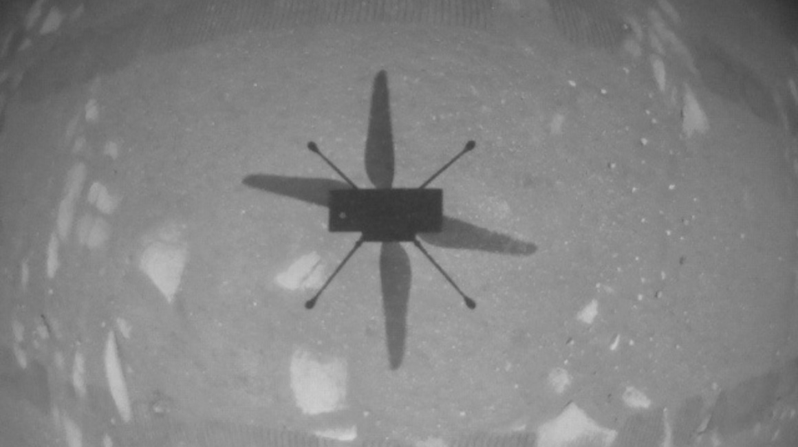 El Ingenuity captado por una cámara a bordo apuntando hacia abajo mientras el helicóptero estaba en el aire.