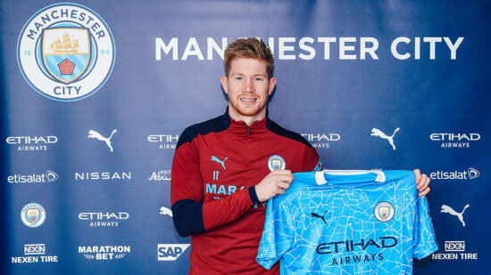 Kevin De Bruyne sostiene la camiseta del Manchester City, luego de firmar su renovación, el 7 de abril de 2021.